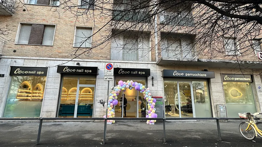 Esterno del salone con le insegne Coco nail spa e Coco parrucchiere e un arco di palloncini all'ingresso